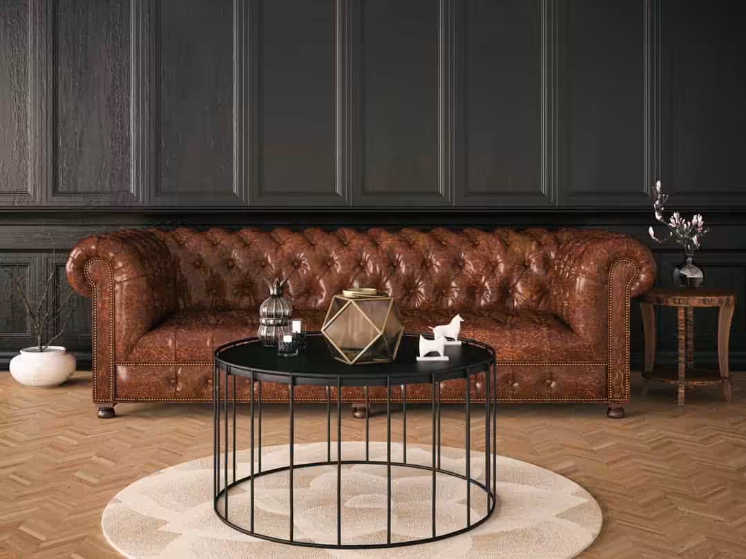 A modern living space with a Chesterfield sofa and dark green wooden panel walls